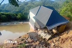 Sạt lở đường Quốc lộ 217, đoạn qua xã Trung Hạ, tỉnh Thanh Hóa làm một ngôi nhà sắp sụp xuống sông. (Ảnh: Nguyễn Nam/TTXVN)