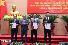 Phó Bí thư Thường trực Thành ủy Hà Nội Nguyễn Văn Phong trao quyết định điều động cán bộ. (Ảnh: Văn Điệp/TTXVN)