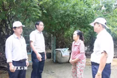 Lãnh đạo Ủy ban Nhân dân xã Điện Bàn Tây vận động người dân nhận tiền đền bù giải phóng mặt bằng phục vụ các công trình trọng điểm. (Ảnh: Hữu Ka/TTXVN phát)