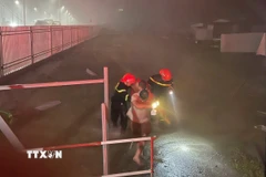 Đội Phòng cháy chữa cháy và Cứu nạn cứu hộ số 1 cứu hộ thành công 4 người bị mắc kẹt trong căn nhà ở phường Trường Vinh. (Ảnh: TTXVN phát)