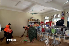 Với phương châm "nước rút đến đâu, dọn dẹp ngay đến đó", giáo viên và các lực lượng chức năng đang khẩn trương dọn dẹp, vệ sinh trường lớp. (Ảnh: Hoàng Ngà/TTXVN)