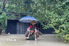 Lực lượng vũ trang hỗ trợ di dời trẻ em ra vùng an toàn. (Ảnh: TTXVN phát)