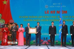 Phó Chủ tịch Quốc hội Vũ Hồng Thanh trao Huân chương Lao động hạng Nhất cho Viện Y học biển. (Ảnh: Minh Thu/TTXVN)