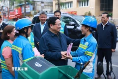 Thủ tướng Phạm Minh Chính thăm, chúc Tết công nhân đang thu gom, vận chuyển, xử lý rác thải khu vực Yên Thế-Nguyễn Thái Học. (Ảnh: Dương Giang/TTXVN)