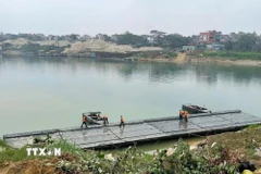 Các lực lượng quân đội đang khẩn trương thi công lắp đặt cầu phao qua sông Lô phục vụ nhân dân đón Tết Nguyên đán 2026. (Ảnh: Nguyễn Văn Cảnh/TTXVN)