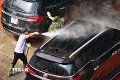 Người làm dịch vụ rửa xe luôn tay không nghỉ trong những ngày cận Tết. (Ảnh: Thanh Tùng/TTXVN)