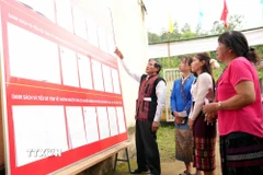 Cử tri Bru-Vân Kiều nghiên cứu danh sách ứng cử viên được niêm yết tại khu vực bỏ phiếu bản Nước Đắng, xã Trường Sơn (Quảng Trị). (Ảnh: Tá Chuyên/TTXVN)