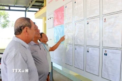 Cử tri ở thôn Văn Lâm 2 (xã Thuận Nam, tỉnh Khánh Hòa) tìm hiểu tóm tắt tiểu sử người ứng cử tại đơn vị bầu cử số 3, khu vực bỏ phiếu số 5. (Ảnh: Công Thử/TTXVN)