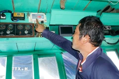 Ngư dân Gia Lai kiểm tra thiết bị giám sát hành trình trước khi đi biển. (Ảnh: Đình Quân/TTXVN)