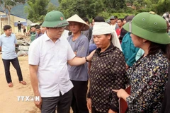 Phó Thủ tướng Chính phủ Lê Thành Long thăm hỏi, động viên gia đình bị thiệt hại về người do mưa lũ ở xã Chiềng Sơ. (Ảnh: Quang Quyết/ TTXVN)