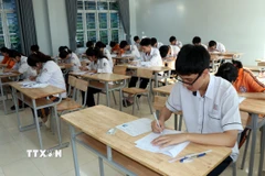 Các thí sinh ghi thông tin trên bài thi. (Ảnh: Nguyễn Lành/ TTXVN)