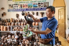 Du khách tìm hiểu sản phẩm gốm tại Hợp tác xã gốm Chăm Bàu Trúc (huyện Ninh Phước, Ninh Thuận). (Ảnh: Nguyễn Thành/TTXVN)