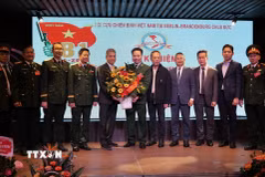 Đại sứ Nguyễn Đắc Thành tặng hoa chúc mừng Hội Cựu hiến binh Việt Nam tại Berlin- Brandenburg. (Ảnh: Thu Hằng /TTXVN)