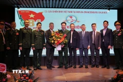 Đại sứ Nguyễn Đắc Thành tặng hoa chúc mừng Hội Cựu hiến binh Việt Nam tại Berlin- Brandenburg. (Ảnh: Thu Hằng /TTXVN)