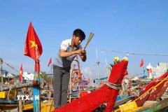 Ngư dân làm lễ "cúng thuyền", cầu yên, cầu lộc, mong biển cả mưa thuận gió hòa, tôm cá đầy khoang. (Ảnh: Xuân Tiến/TTXVN)