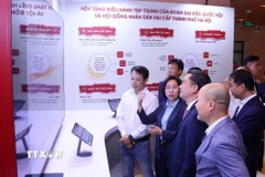 Các đại biểu trải nghiệm Nền tảng Điều hành tập trung của Đoàn đại biểu Quốc hội và Hội đồng nhân dân hai cấp Thành phố Hà Nội. (Ảnh: Văn Điệp/TTXVN)