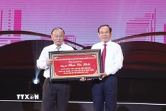Bí thư Thành ủy TP Hồ Chí Minh Nguyễn Văn Nên trao bảng tôn vinh cho gia đình cố Thủ tướng Chính phủ Phan Văn Khải. (Ảnh: Hữu Duyên/ TTXVN)
