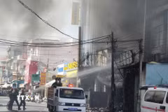 Lực lượng phòng cháy chữa cháy tiến hành dập lửa cứu nạn cứu hộ trong vụ hỏa hoạn ở cửa hàng. (Ảnh: Huỳnh Phúc Hậu/TTXVN)