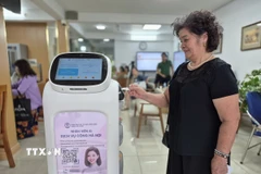 Người dân trải nghiệm Robot AI áp dụng công nghệ trí tuệ nhân tạo hỗ trợ thực hiện các thủ tục hành chính ở phường Cửa Nam. (Ảnh: Nguyễn Thắng/TTXVN)