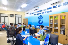 Người dân thực hiện thủ tục hành chính tại Điểm hỗ trợ dịch vụ công số Thư Lâm, thành phố Hà Nội. (Ảnh: Trung Nguyên/TTXVN)