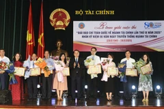 Thứ trưởng Bộ Tài chính Nguyễn Đức Chi trao giải Tập thể - Bằng khen của Bộ trưởng Bộ Tài chính cho tập thể có thành tích tiêu biểu, đóng góp tích cực vào công tác thông tin, tuyên truyền về lĩnh vực tài chính. (Ảnh: Vietnam+)