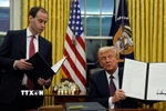 Tổng thống Mỹ Donald Trump (phải) ký sắc lệnh hành pháp ngay sau lễ nhậm chức, tại Nhà Trắng ở Washington DC., ngày 20/1/2025. (Ảnh: AP/TTXVN)