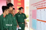 Các chiến sỹ xem kỹ danh sách người ứng cử. (Ảnh: Công Thử/TTXVN)
