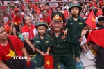Ông cháu cùng chờ xem buổi tổng hợp luyện diễu binh, diễu hành A80 lần thứ 2. (Ảnh: Văn Điệp/TTXVN)