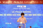 Tổng Giám đốc TTXVN Vũ Việt Trang ủng hộ đồng bào khắc phục hậu quả bão lũ. (Ảnh: Tuấn Anh/TTXVN)