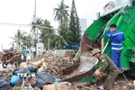 Xe thu gom rác và công nhân vệ sinh môi trường từ thành phố Hồ Chí Minh đến Khánh Hòa hỗ trợ thu gom rác trên bãi biển Nha Trang. (Ảnh: Phan Sáu/TTXVN)