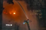 Lính cứu hỏa nỗ lực dập lửa tại hiện trường cháy tòa chung cư ở quận Tai Po, Hong Kong (Trung Quốc) ngày 26/11/2025. (Ảnh: THX/TTXVN)