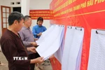 Người dân xem danh sách cử tri được niêm yết. (Ảnh: Mạnh Minh/TTXVN)