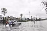 Có người phải đẩy xe ôtô do chết máy giữa đường vì ngập nước. (Ảnh: Thanh Vân/TTXVN)