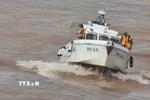 Lực lượng Bộ đội Biên phòng tỉnh Quảng Trị tìm kiếm thi thể thuyền viên trên vùng biển cửa sông Gianh. (Ảnh: Nguyên Linh/TTXVN)