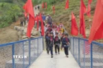 Học sinh tại 5 thôn bị cô lập qua cầu để đến trường an toàn. (Ảnh: Dư Toán/TTXVN)