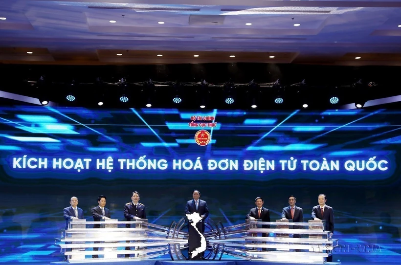 Thủ tướng Phạm Minh Chính và các đại biểu ấn nút kích hoạt Hệ thống Hóa đơn Điện tử Toàn quốc. (Ảnh: Phạm Hậu/TTXVN)