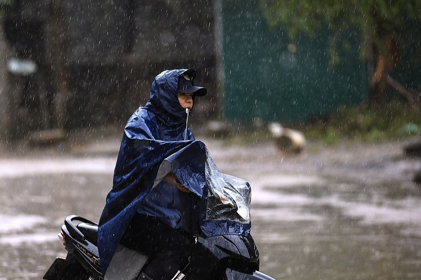 Người dân chật vật lưu thông trong mưa. (Ảnh: Trọng Đạt/TTXVN)