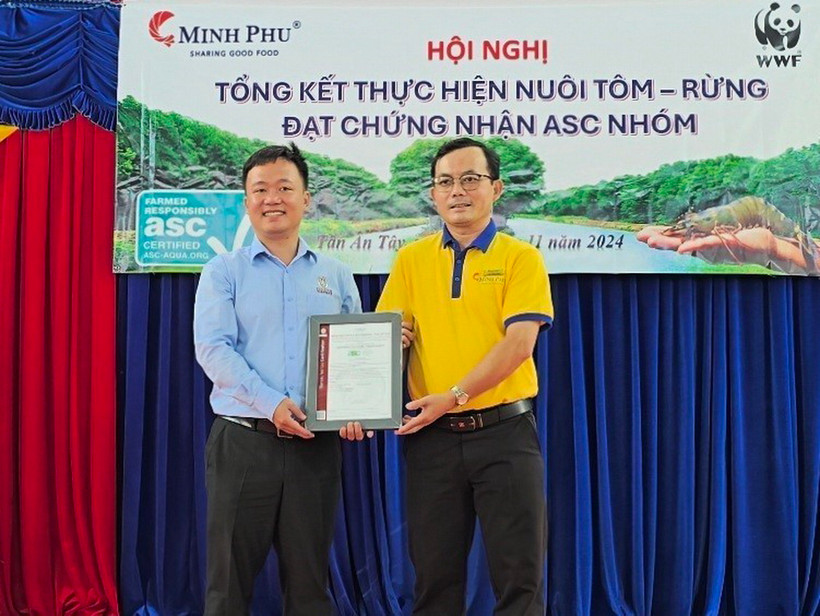 Ông Trần Phương Đại, Giám đốc kinh doanh Bureau Veritas Vietnam (BV) trao Chứng nhận ASC nhóm cho ông Lâm Thái Xuyên (phải), Giám đốc Công ty trách nhiệm hữu hạn Xã hội tôm chứng nhận Minh Phú. (Ảnh: Kim Há/TTXVN)