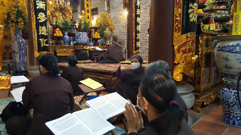 Phật tử hành lễ nhưng vẫn thực hiện nghiêm đeo khẩu trang phòng chống dịch. (Ảnh: Đinh Thuận/TTXVN)