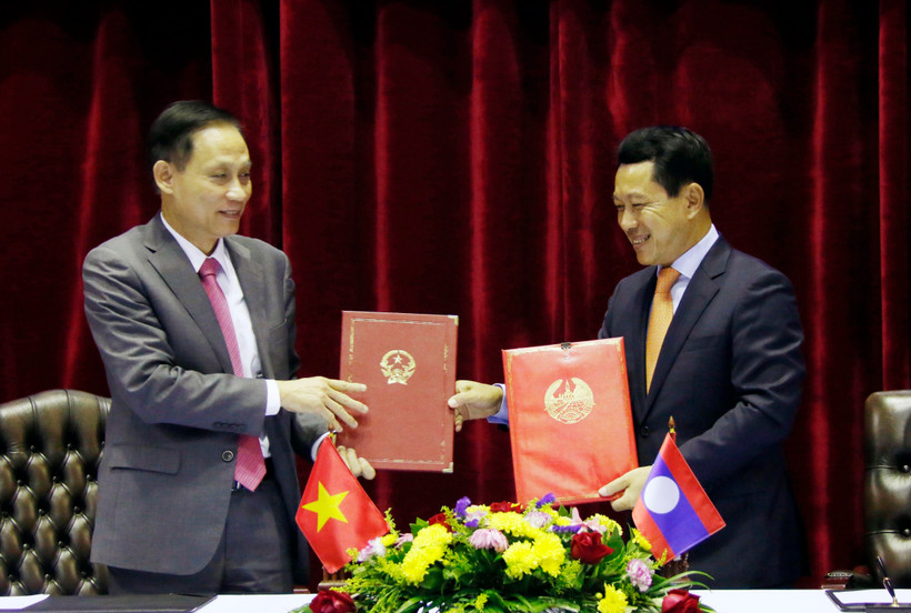 Thứ trưởng Bộ Ngoại giao Lê Hoài Trung và Bộ trưởng Ngoại giao Lào Saleumsay Kommasith đang trao đổi Biên bản cuộc họp. (Ảnh: Phạm Kiên/TTXVN)