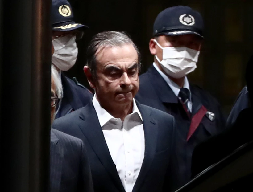 Cảnh sát áp giải cựu Chủ tịch Nissan Carlos Ghosn (giữa) rời khỏi khu giam giữ ở Tokyo, sau khi ông được trả tự do có bảo lãnh, ngày 25/4/2019. (Ảnh: AFP/TTXVN)