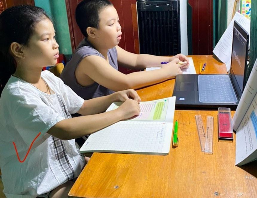 Nhiều trường hợp 2 học sinh phải học chung trên một thiết bị. (Ảnh: TTXVN phát)