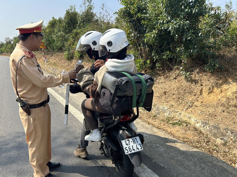 Cảnh sát giao thông tại chốt Sao Mai tặng nước uống miễn phí cho người dân khi đi qua địa bàn tỉnh Kon Tum về quê đón Tết. (Ảnh: TTXVN phát)
