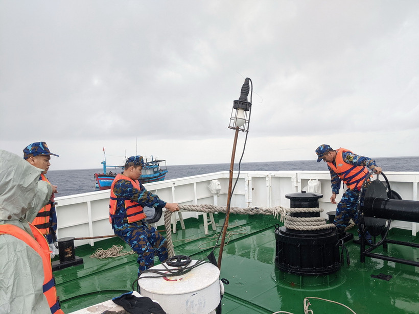 Chiến sỹ tàu Hải quân 468 làm dây để lai kéo tàu của ngư dân Phú Yên. (Ảnh: TTXVN phát)