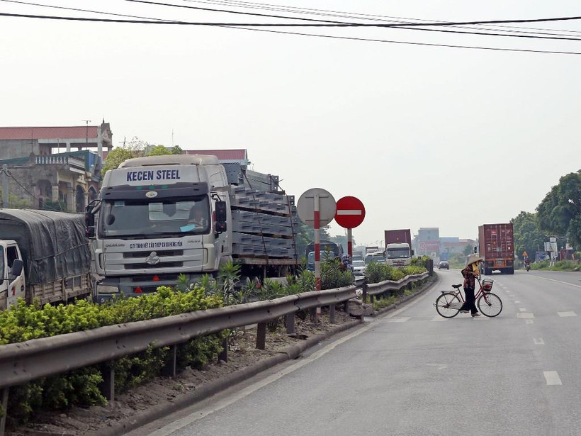 Lưu lượng xe đông, đường xuống cấp và hệ thống đường gom, cầu vượt chưa được thiết kế đầy đủ là những nguy hiểm rình rập với người đi trên Quốc lộ 5. (Ảnh: Huy Hùng/Vietnam+)