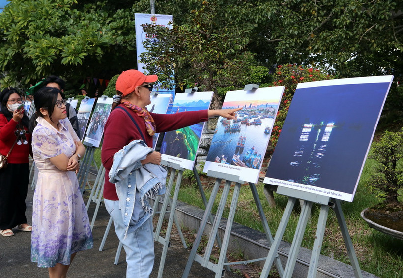 Khách du lịch quốc tế tham quanTriển lãm ảnh "Chuyện làng biển" tại ngày hội. (Ảnh: Trần Lê Lâm/TTXVN)