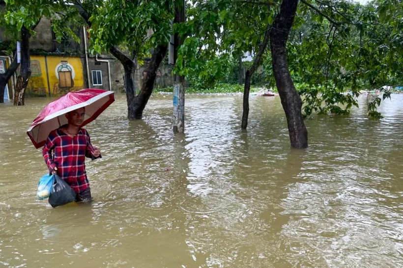 Một người đàn ông lội qua nước lũ ở Sylhet, Bangladesh. (Nguồn: AFP)