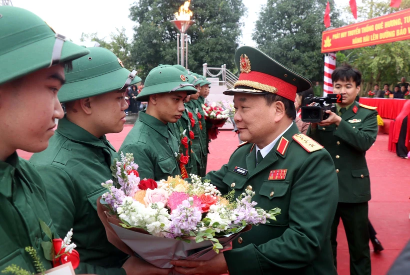 Thượng tướng Hoàng Xuân Chiến, Thứ trưởng Bộ Quốc phòng tặng hoa tân binh lên đường nhập ngũ tại huyện Kim Động, tỉnh Hưng Yên. (Ảnh: Đinh Văn Nhiều/TTXVN)