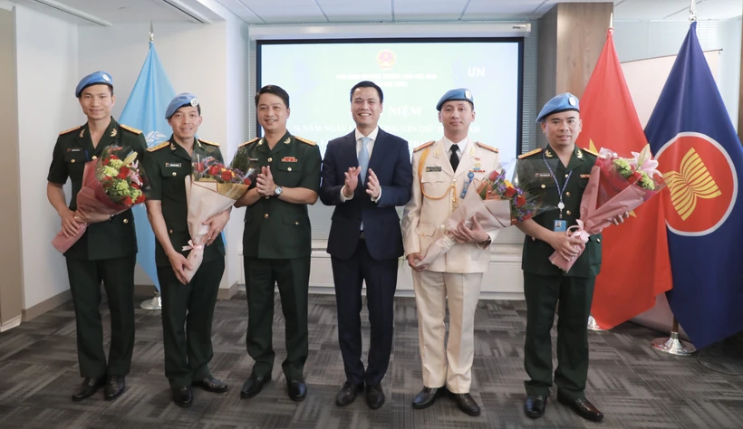 Đại sứ, Trưởng Phái đoàn Đại diện thường trực Việt Nam tại Liên hợp quốc Đặng Hoàng Giang tặng hoa, chúc mừng các sỹ quan thuộc lực lượng Gìn giữ Hòa bình của Bộ Quốc phòng và Bộ Công an Việt Nam đang làm việc tại Cục Hoạt động Hoà bình Liên hợp quốc. (Ảnh: Thanh Tuấn/TTXVN)
