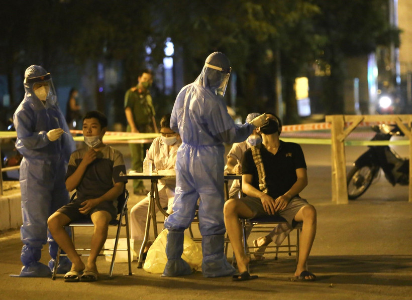 Lực lượng y tế lấy mẫu xét nghiệm đối với những người có liên quan đến ca nghi nhiễm COVID-19 tại số 307 phố Trần Đại Nghĩa, Hà Nội. (Ảnh: Hoàng Hiếu/TTXVN)